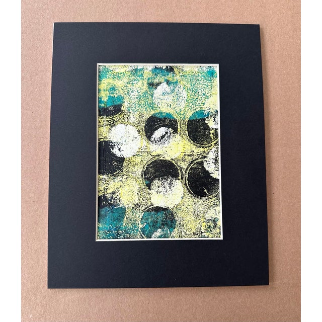An energetic and richly textured original abstract monoprint featuring layered circular forms in dramatic shades of teal,...