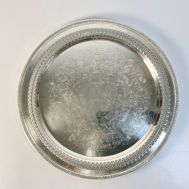 This is a lovely butler serving silverplate tray from Wm. Roger’s. It features an etched tray with a rolled design rim....