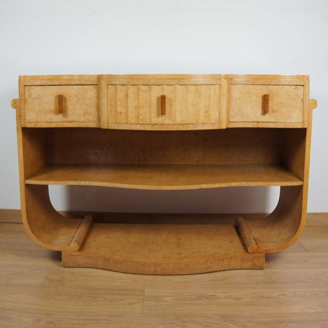 An Art Deco console table by Harry & Lou Epstein. Burr walnut veneered with original walnut handles. Set over U-shaped...