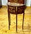 This elegant French-style demilune side table features a rich dark wood finish enhanced by intricate floral marquetry and...