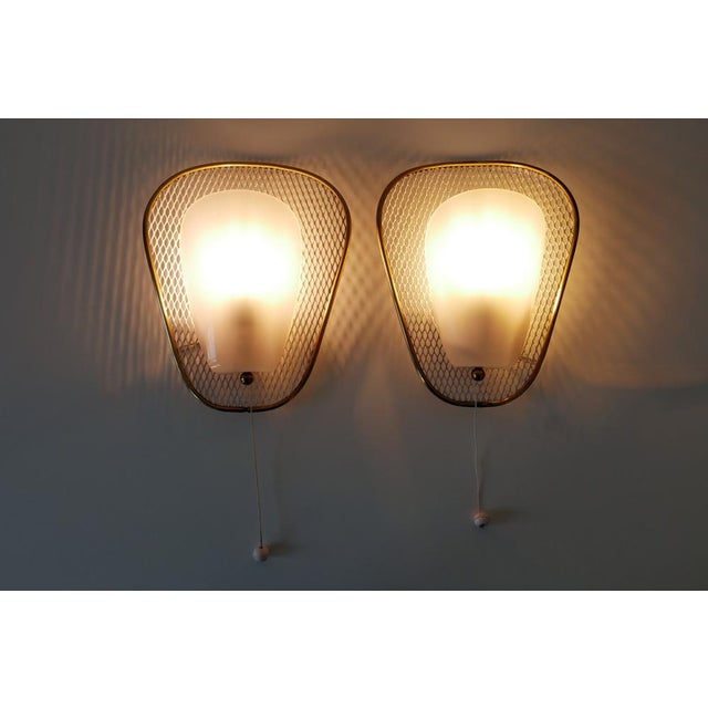 Set of two rare, elegant and highly decorative mid-century modern sconces or wall fixtures. Designed & manufactured in...