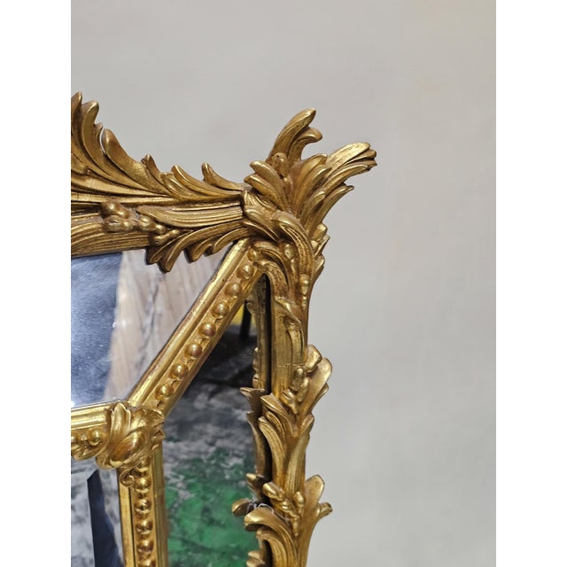 The central rectangular mirror plate within a beaded surround and bordered by mirrored plates within a palm frond outer...