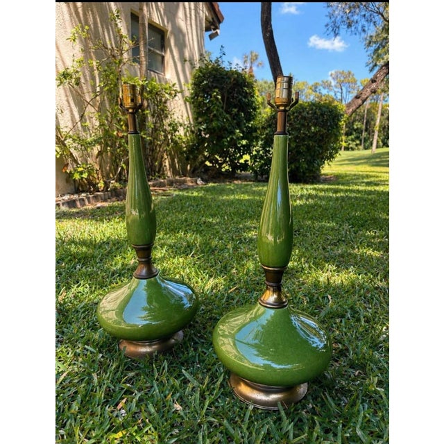 Beautiful pair of vintage table lamps featuring glossy green glazed ceramic and bronze/gold-tone metal details. Elegant...