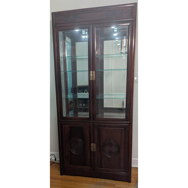 This is a mid-to-late 20th-century Chinese solid hardwood (rosewood finish) display cabinet/curio hutch featuring...