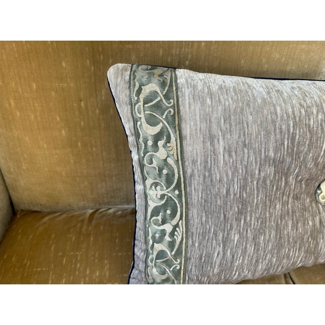 A pillow made and accented with Fortuny border fabric and button tufting