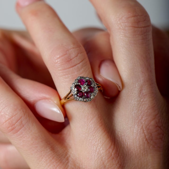 This captivating Victorian cluster ring is a richly detailed expression of late 19th-century romance and craftsmanship. At...