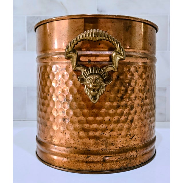 Vintage hammered copper coal scuttle bucket featuring an ornate brass satyr‑style handle, perfect for adding character to...