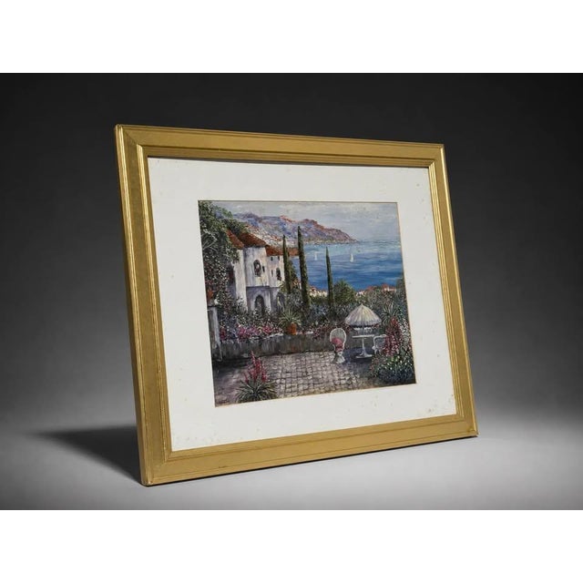 Elegant framed coastal landscape artwork featuring a seaside villa, garden patio, ocean view, mountains, and...