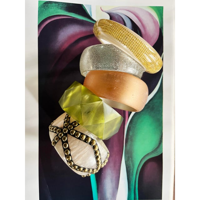 Ivory lucite base with marbled texture overlaid in a geometric brass stud pattern. The contrast of creamy swirls and...
