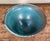 This hand-thrown studio pottery bowl is finished in a mottled turquoise and dark iron glaze over stoneware and is signed...