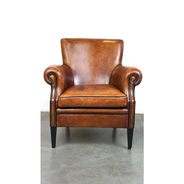 This is a refined and comfortable sheepskin leather armchair/fauteuil with a beautiful finish, featuring a loose seat...