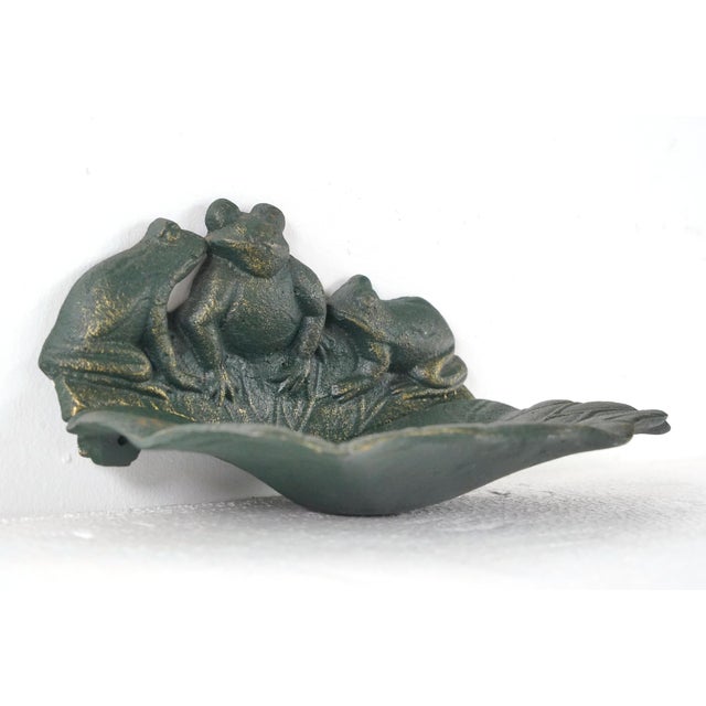 Vintage green painted cast iron bird feeder or bath with a gold wash layer. It features a group of frogs resting on a...