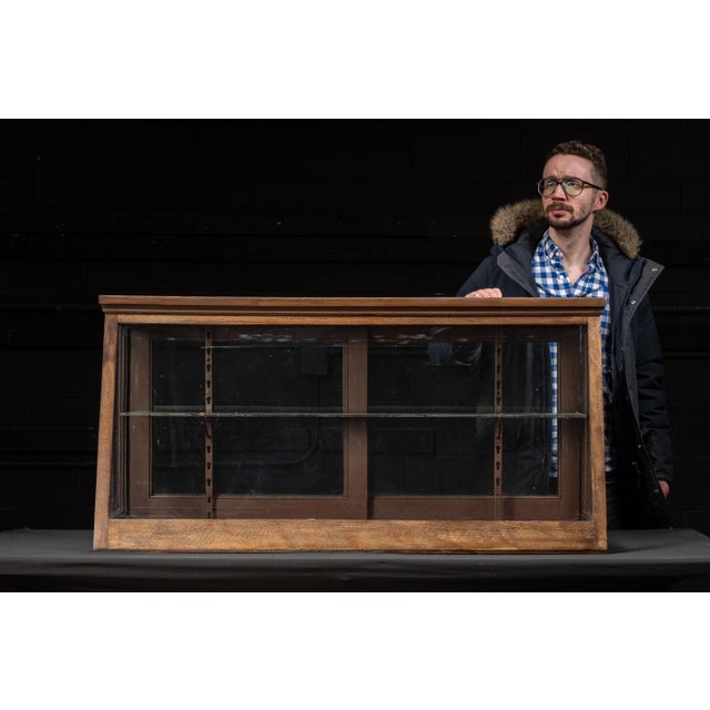Antique display or show case with glass shelving. This piece features a single glass shelf inside, with the option to...