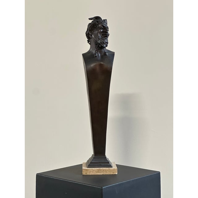 Bronze bust depicting a satyr, characterized by a marked theatrical and grotesque expressiveness. The face features a...