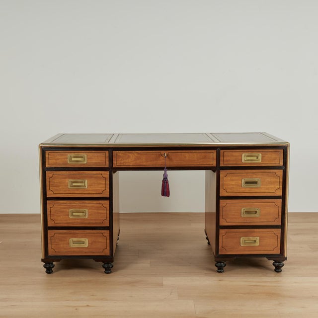 Impressive vintage campaign style desk crafted in satinwood with ebonized trim, featuring three tooled leather panels on...
