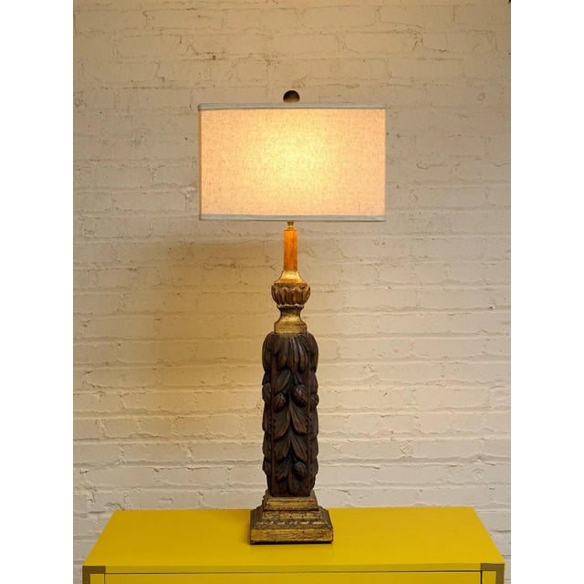 A dramatic vintage table lamp featuring a hand-carved solid wood column adorned with flowing acanthus leaves and classical...