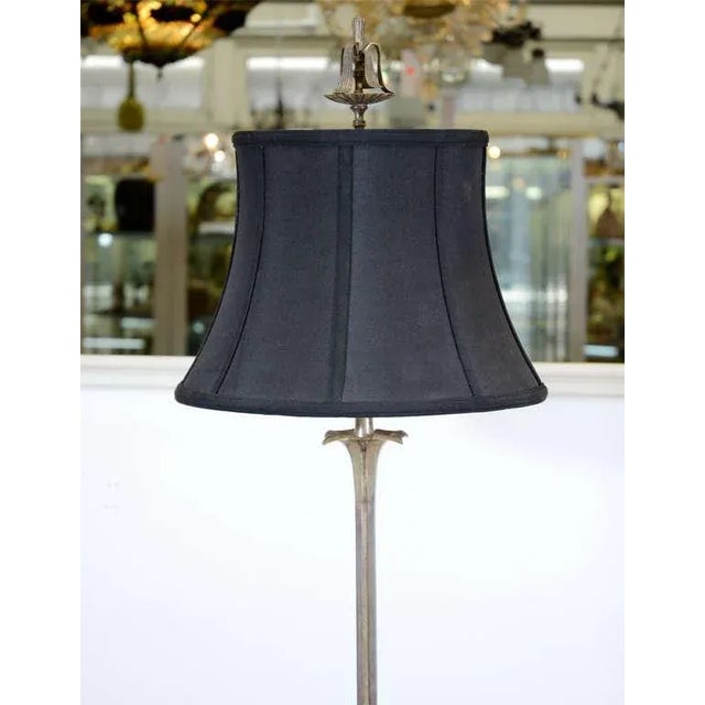 An Art Deco floor lamp in nickeled bronze with four doré gold bronze deer details on a marble base and a fantastic water...