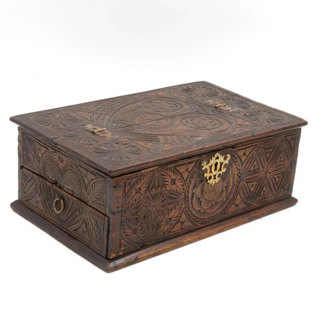 A 17th century carved oak box with side drawer dated 1655. Intricate carvings on all sides, including geometric figures...