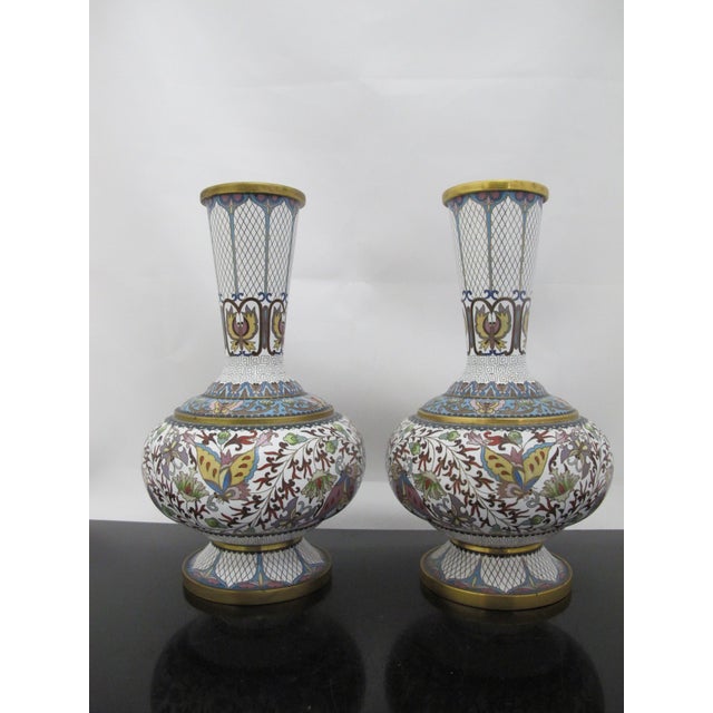 Pair of Chinese cloisonné 20th century vases. Enamel on brass, showing white ground adorned with bands of colorful floral,...