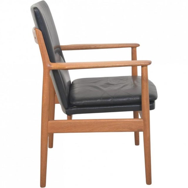 Arne Vodder 431 lounge chair with a frame of teak and upholstery in black leather. The chair is from the 1970s and appears...