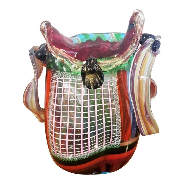 This handbag-shaped sculpture is an exclusive Murano glass vase entirely handmade with assorted colors in glass paste and...