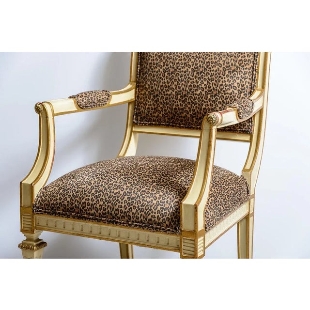 Pair of French Louis Sixteenth style Fauteuil arm chairs painted cream with gold accents. The leopard upholstery is new....