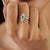 The Diamond-Studded Regal Emerald Engagement Ring features an elegant marquise-shaped halo surrounding a vibrant oval...