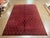 Hand-loomed Nepal wool rug featuring a deep red field with an allover repeating geometric motif in a subtle tonal...