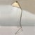 Elegant Italian floor lamp dating from the 1950's, featuring a slender brass frame and tripod legs. The tapered shade has...