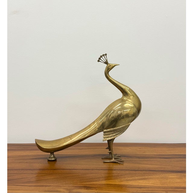 Gracefully sculpted from solid brass, this vintage peacock features an elongated, flowing silhouette with a stylized fan...