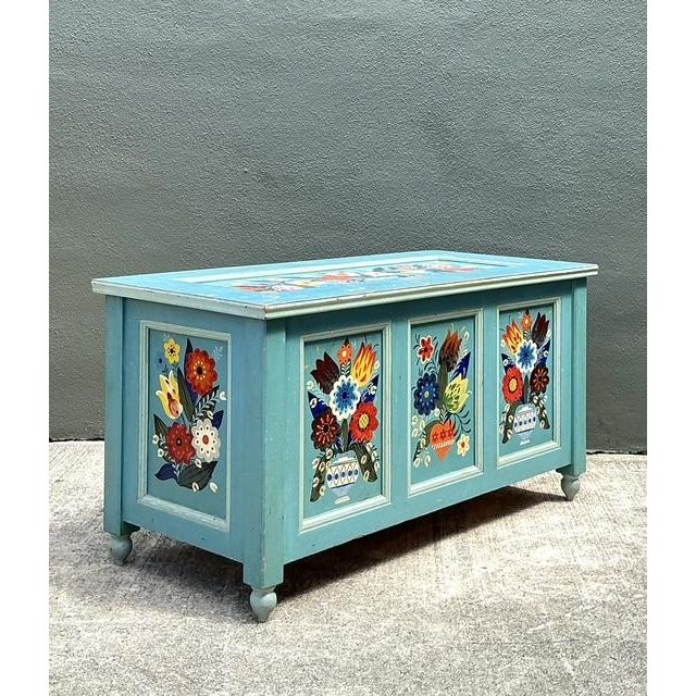 This charming vintage blanket trunk is a vibrant celebration of European folk art traditions, featuring exquisite hand-...