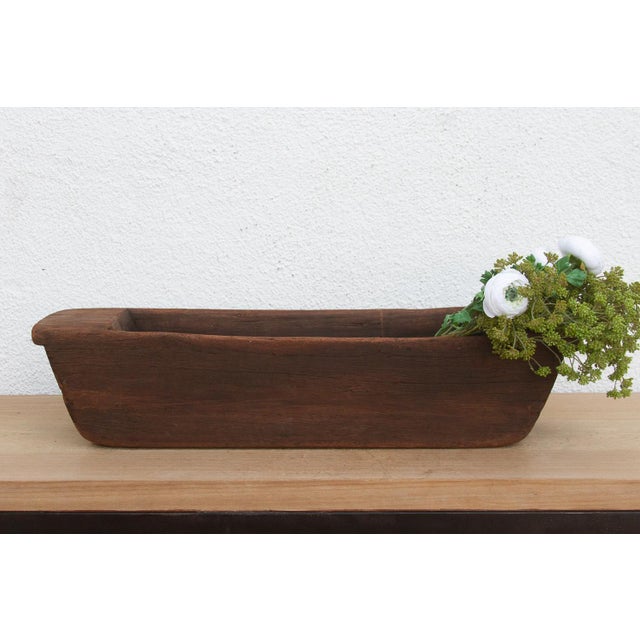 Carved from a single, massive log of hardwood, this antique wooden trough was likely originally used in a village setting...