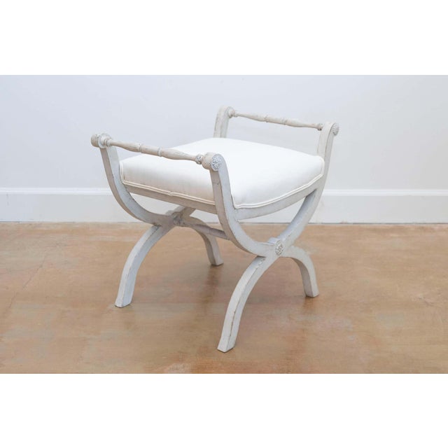 A Swedish Empire style painted wooden Curule stool from the mid-19th century, with spindle arms, X-form base and new...