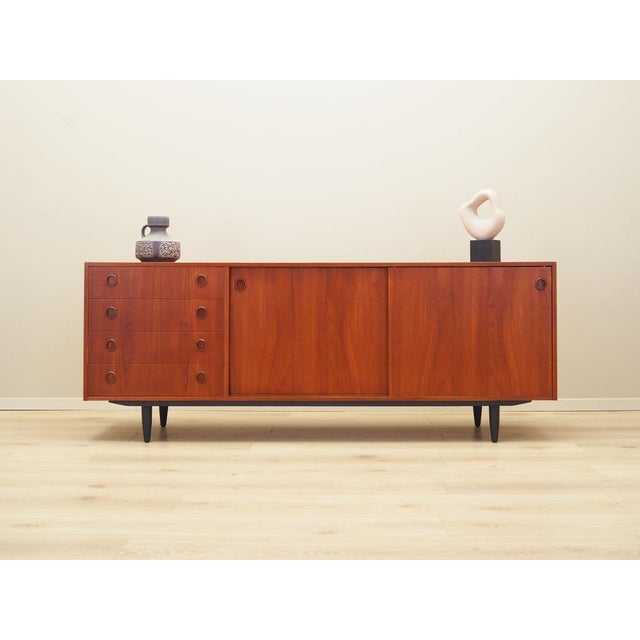 The sideboard was made in the 1970s, Danish production. The structure is covered with teak veneer. Legs made of solid wood...