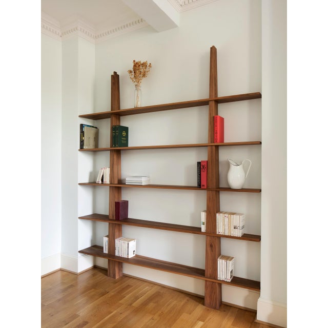A refined bookcase in solid walnut that balances sculptural presence with everyday practicality. Warm tones and a deep,...