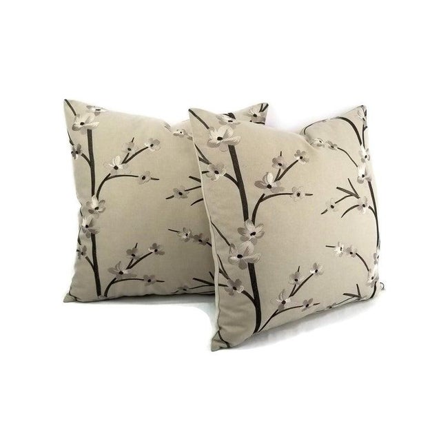 Embroidered tree branch with small flower pattern pillow cover. The embroidery has black silver and darker gray threads to...