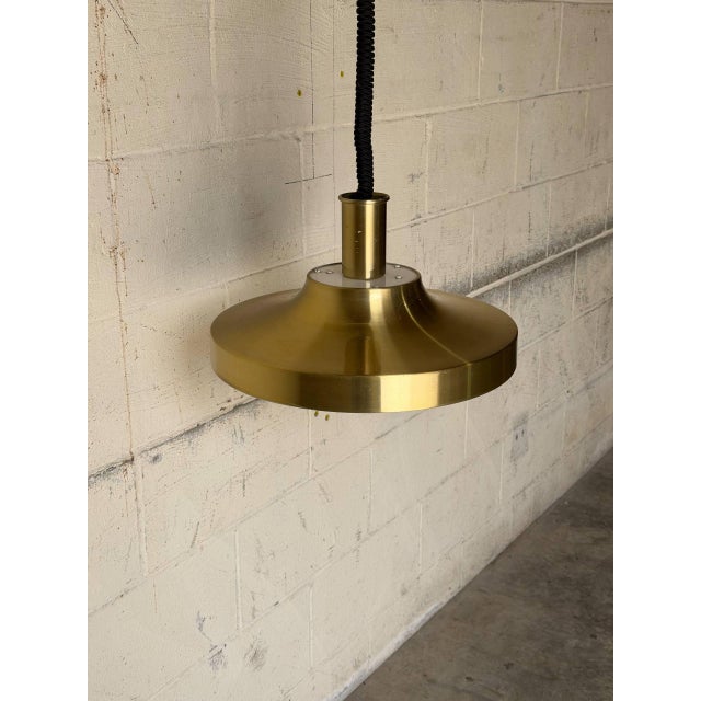 This striking ceiling pendant light features a contoured metallic shade that casts focused downward illumination. Its...