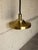 This striking ceiling pendant light features a contoured metallic shade that casts focused downward illumination. Its...