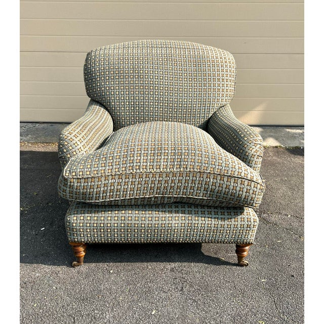 George Smith Standard Arm Style Chair with down seat cushions. The chair sits on turned legs with brass casters. The chair...