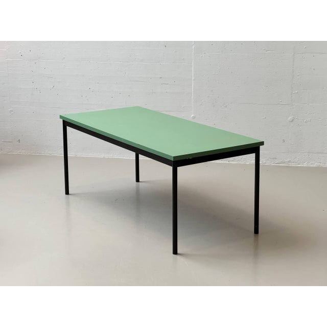 A simple, functional dining table made in switzerland by stein am rhein. The understated design combines a matte green...