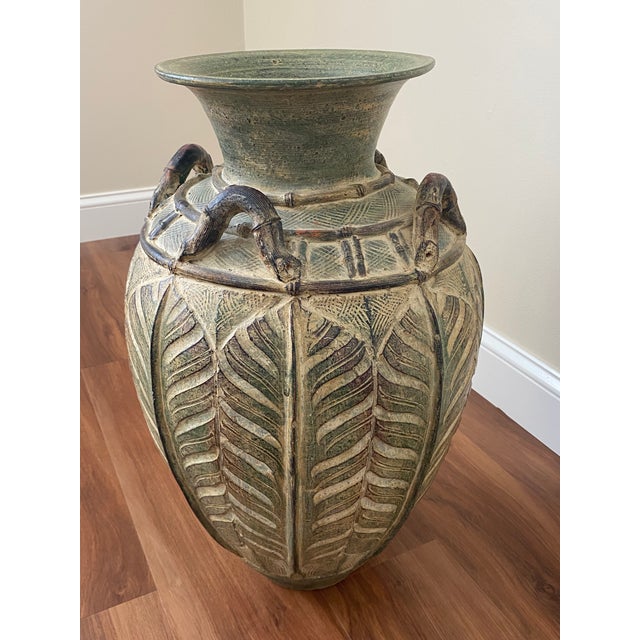A substantial mid-20th century Chinoiserie-style ironstone floor vase featuring a deeply carved monstera or fern leaf...