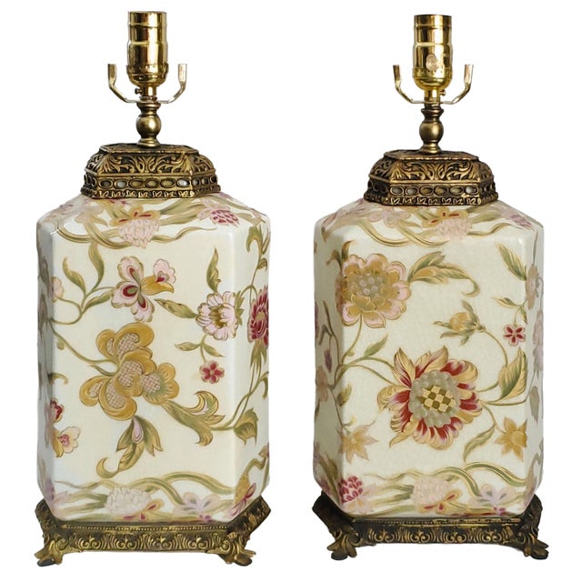 Offering a pair of vintage Chinese porcelain table lamps with flowers and leaves with gold detailing, circa Late 20th...