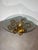 An elegant vintage coffee table featuring a sculptural gilt iron base with beautifully hand-forged scrollwork and a...