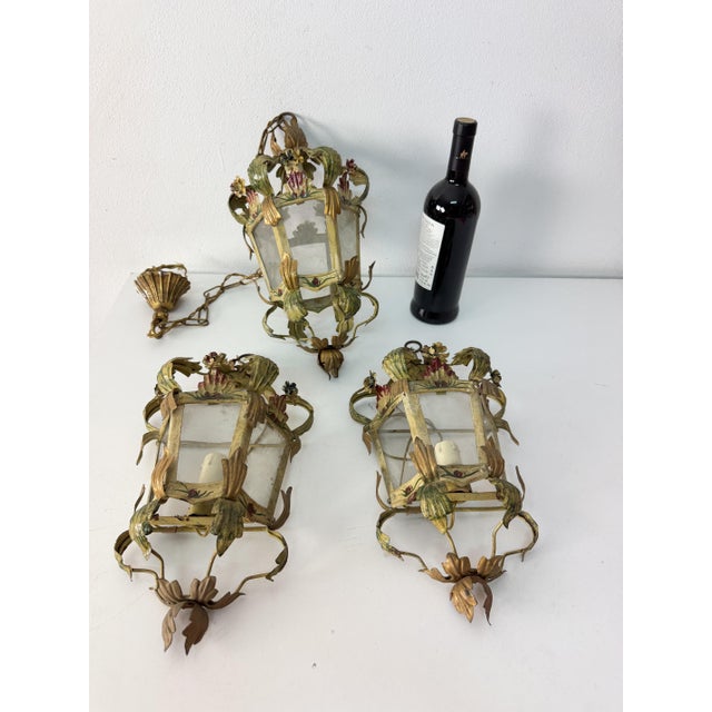 Set of 3 lamps (2 wall lamps and 1 small chandelier) in decorated wrought iron, 1950s. E14 bulbs. from a villa in the...