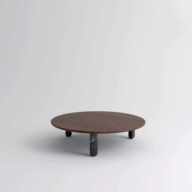 Large round walnut and black marble "sunday" coffee table, jean-baptiste souletie dimensions: 150 d x 35 h cm materials:...