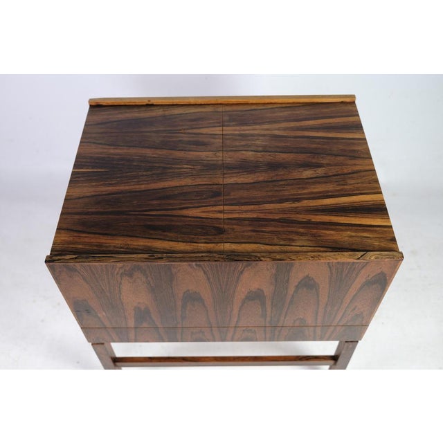 This vintage sewing table / bar table on rosewood legs is a fantastic example of Danish furniture design from the 1960s....