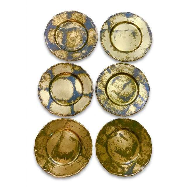 A striking set of six oversized 13-inch dinner plate chargers, finished in hand‑applied gold leaf with a warm, mottled...