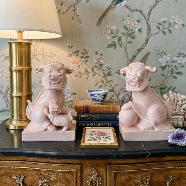 A impressive pair of vintage ceramic guardian lions (foo dogs) finished in a glossy, monochrome pale blush pink glaze....