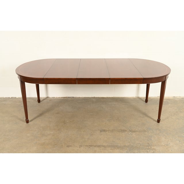 A beautiful Federal or Hepplewhite style extension dining table By Kindel Furniture USA, Circa 1980s Gorgeous book-matched...