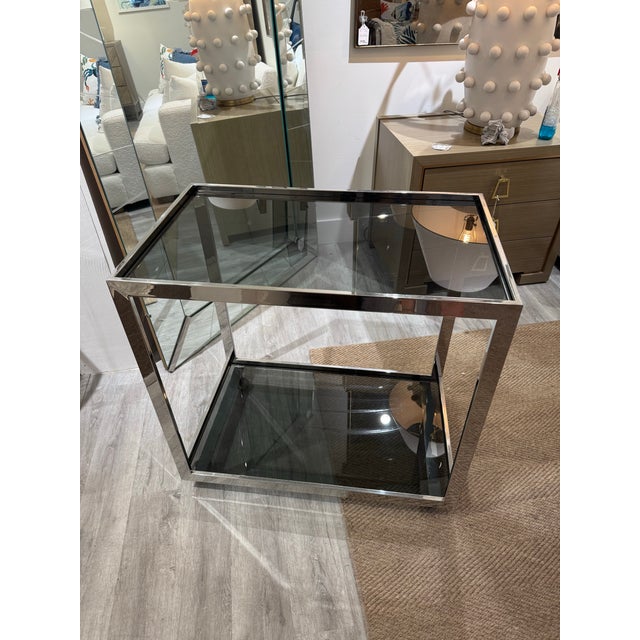 Elevate your entertaining space with this stunning vintage chrome bar cart. Featuring a polished chrome frame with clean...